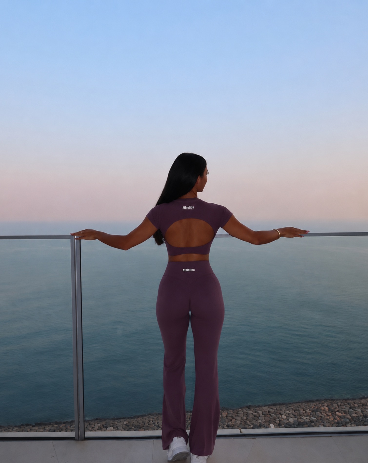 A woman at the coast at golden hour in Athletica Wear
